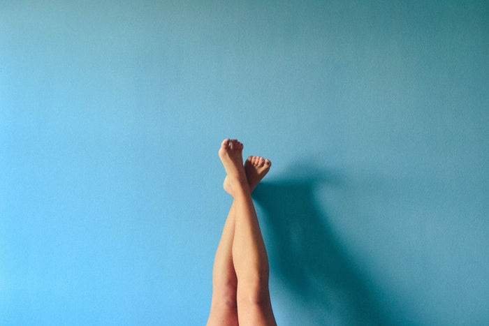 Jambes nues croisées sur fond bleu