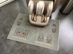 
Hinweis-Fußteppich „Schuhe ausziehen“ vor einem Massagesessel